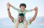 Black family, father and a son sitting on shoulders while outdoor in nature together during a beach vacation. Love, sky or kids with a parent carrying his male child while walking on the coast