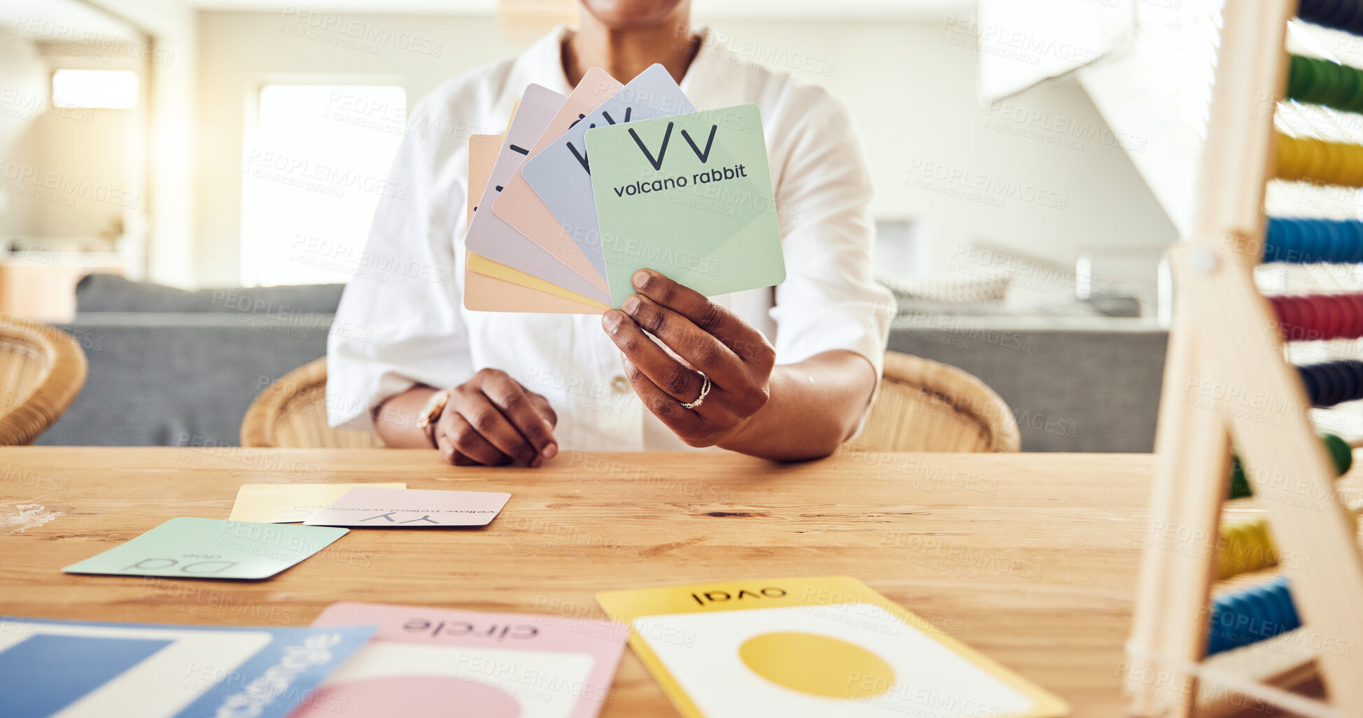 Buy stock photo Education, letter and cards with hands of black woman for teaching, alphabet and language. Homework, lesson and study with tutor at home for learning, reading and phonics schoolwork
