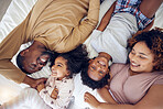 Above, happy and black family laughing in bed, smile and bonding while resting in their home. Top view, smile and children waking up with mother and father in a bedroom, playful and having fun 