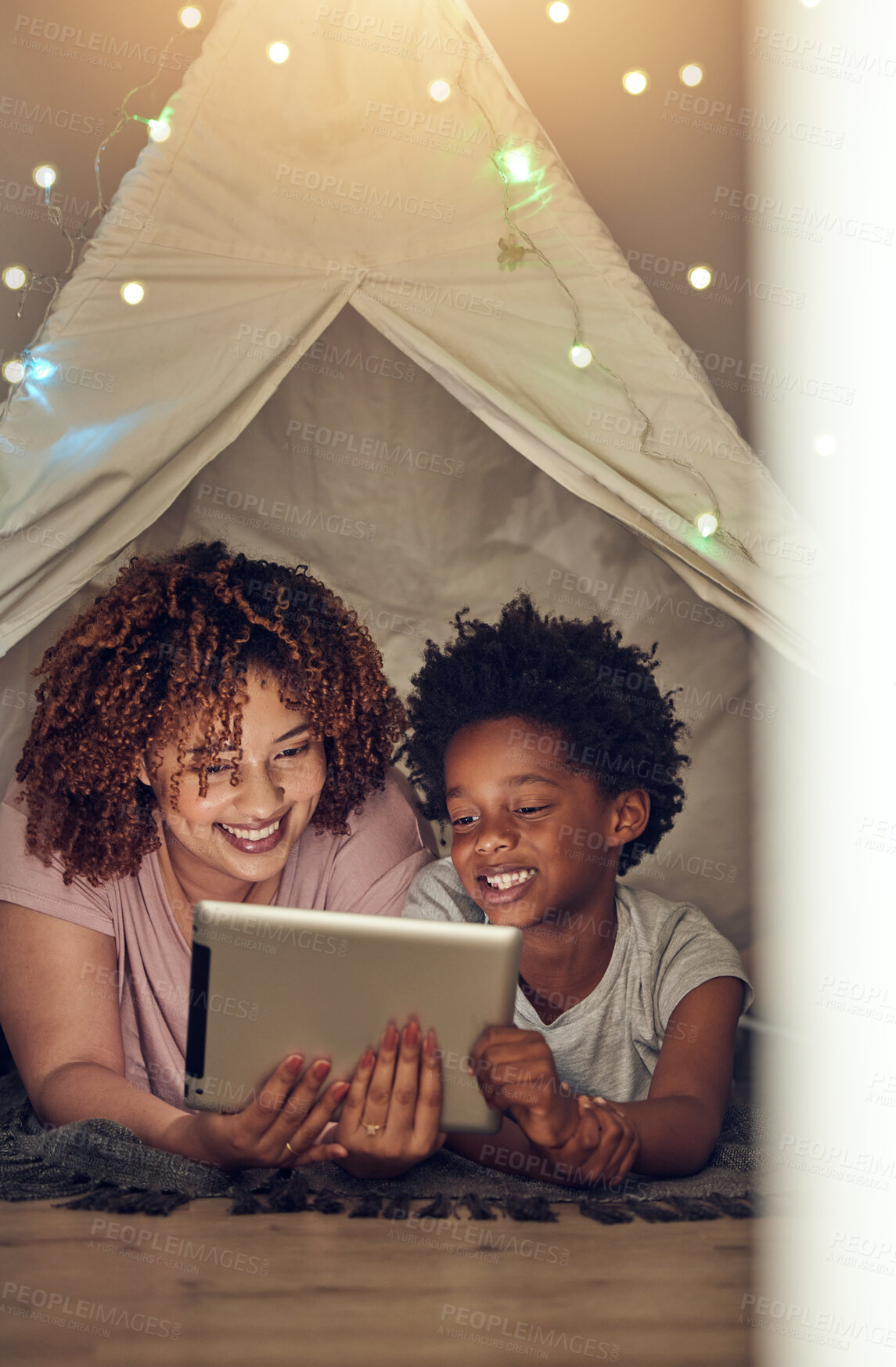 Buy stock photo Tablet, black family and mother with kid in tent at night watching movie, video and having fun in home. Technology, love and smile of happy mixed race mom bonding with boy child while streaming film.
