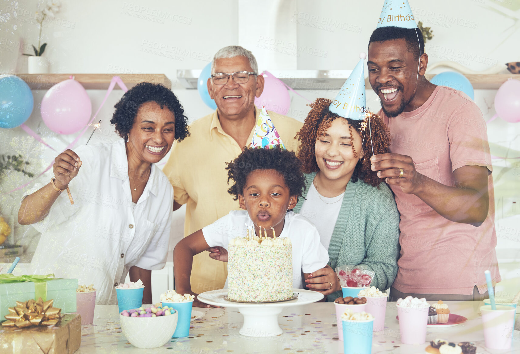 Buy stock photo Birthday party, cake and blow with family in kitchen for celebration, bonding and affectionate. Happiness, excited and grandparents with parents and child at home for surprise, fun and event 