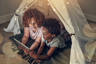 Buy stock photo Black family, tablet and mother with kid in tent at night watching movie, video and having fun in home. Technology, bokeh and smile of happy mixed race mom bonding with boy child while streaming film