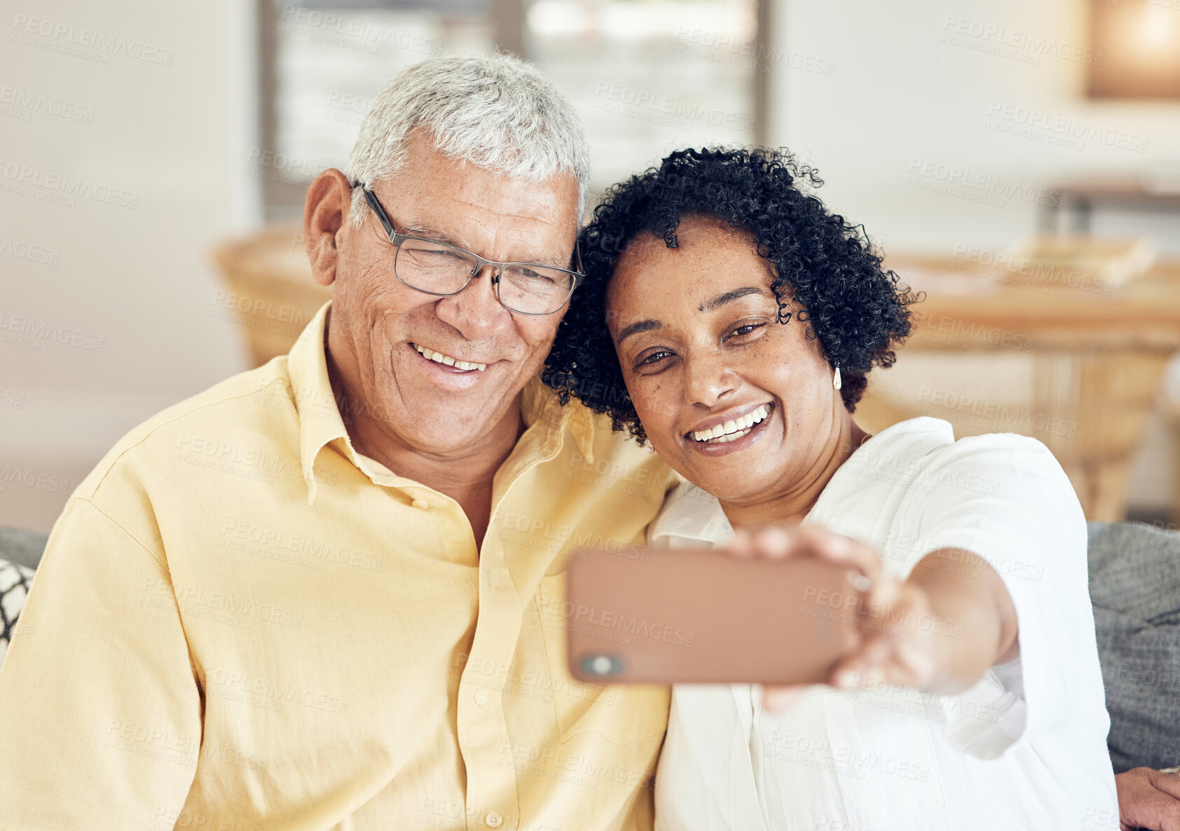 Buy stock photo Senior couple, smile and selfie in home with love, bonding and hug for support, relax and peace on blog app. Elderly man, old woman and social media for profile picture with tech in living room