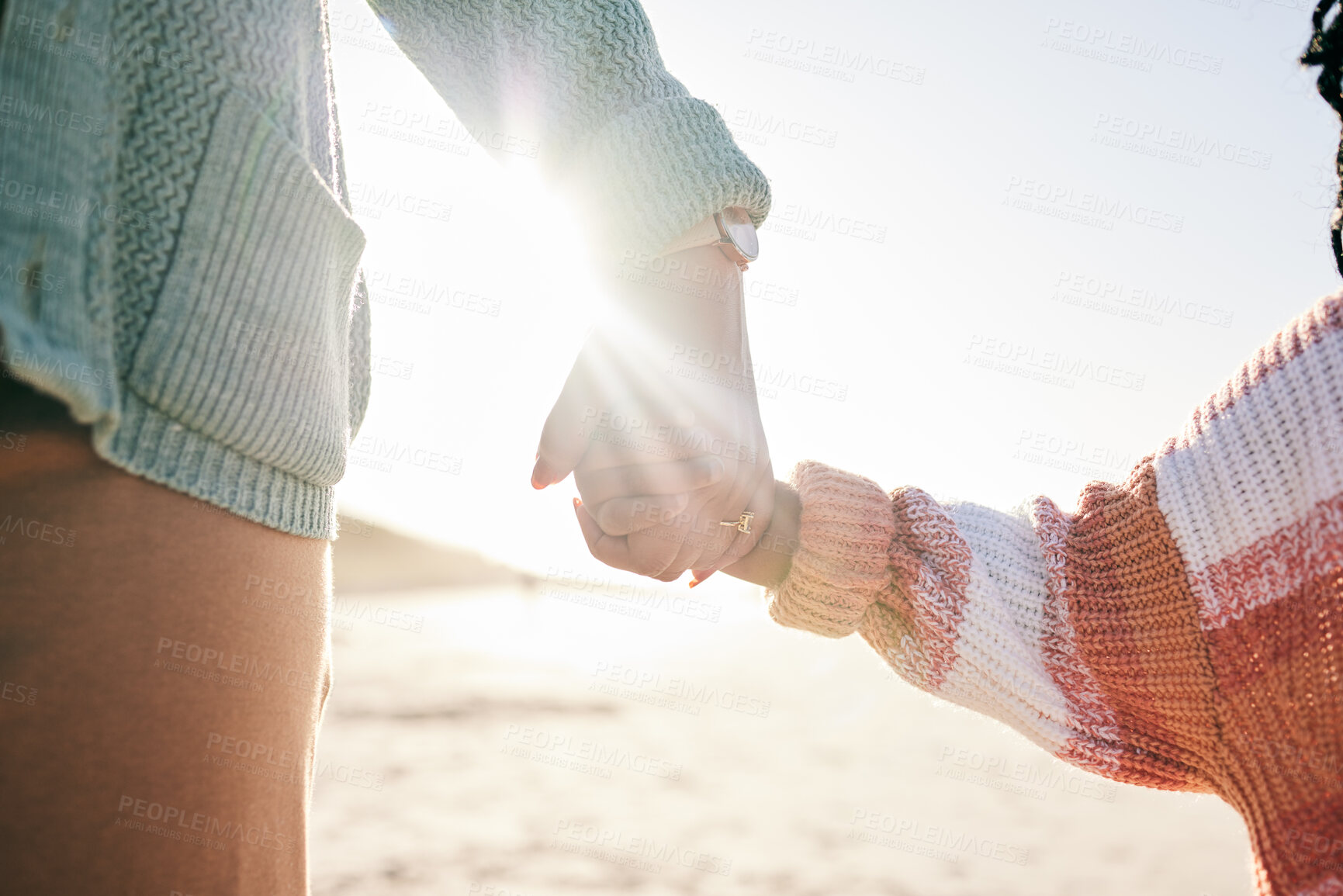 Buy stock photo Family, mother and child holding hands at beach, travel and summer with sunshine lens flare and together outdoor. Trust, support with woman and girl on vacation, love and care in nature with closeup