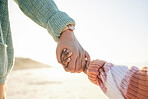 Family, mother and kid holding hands at beach, travel and summer holiday with sunshine and together outdoor. Trust, support with woman and girl on vacation, love and care in nature with closeup