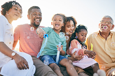 Buy stock photo Relax, happy and bubbles with black family in outdoors for bonding, summer break and generations. Happiness, playful and grandparents with parents and children for free time, weekend or youth