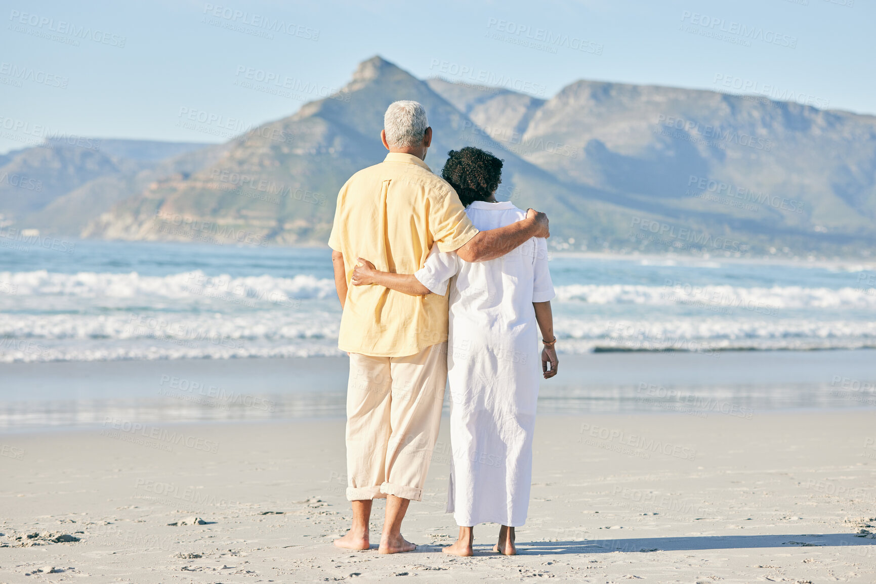 Buy stock photo Old couple at beach, hug and travel with retirement and love outdoor, vacation with ocean view and relax in nature. Peace, zen and tropical island, man and woman watching sea waves, back and wellness