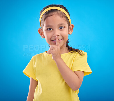 Buy stock photo Young girl secret, portrait and studio with a student feeling happy with blue background. Isolated, cute and adorable child face in a yellow outfit with happiness, whisper and cheerful from gossip
