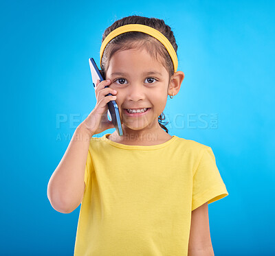 Buy stock photo Phone call, smile and portrait of child on blue background for talking, speaking and chatting online. Technology, communication mockup and face of happy girl in conversation on smartphone in studio