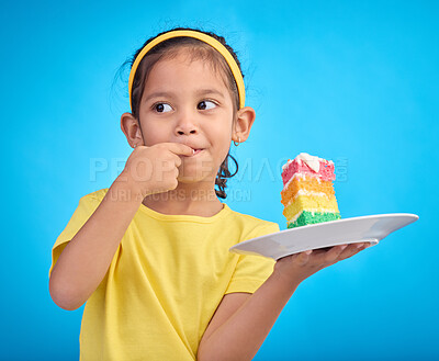 Buy stock photo Birthday cake, taste and young girl with a sweet in studio eating icing for party event dessert. Celebration, rainbow food and hungry kid in a isolated and blue background studio ready to celebrate