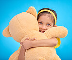 Mockup, portrait and girl with teddy bear, hug and happiness against a blue studio background. Face, female kid and young person embrace fluffy toy, cheerful and child development with fun and joy