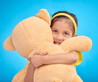 Buy stock photo Mockup, portrait and girl with teddy bear, hug and happiness against a blue studio background. Face, female kid and young person embrace fluffy toy, cheerful and child development with fun and joy