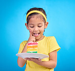 Food, happy and child with rainbow cake on blue background for birthday, celebration and party mockup. Comic, smile and excited young girl with sweet snack in studio with pastry, dessert and eating