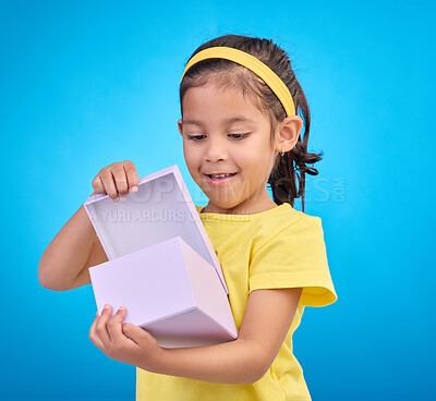 Buy stock photo Box, surprise and child with gift in studio on blue background for present, birthday or celebration. Happiness, smile and isolated young, excited and happy girl opening package, product and parcel