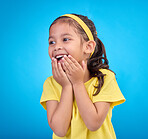 Laughing, happy and child looking curious while isolated on a blue background in a studio. Smile, cheerful and an adorable little girl with a laugh, happiness and innocent delight on a backdrop