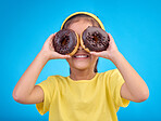 Donut, eyes and covering face of playful cute girl with food isolated against a studio blue background with a smile. Adorable, happy and young child or kid excited for sweet sugar doughnuts