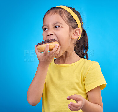 Buy stock photo Donut, eating and sweet with girl in studio for junk food, sugar and happiness. Snack, cake and cute with face of child and dessert for candy diet and chocolate isolated on blue background