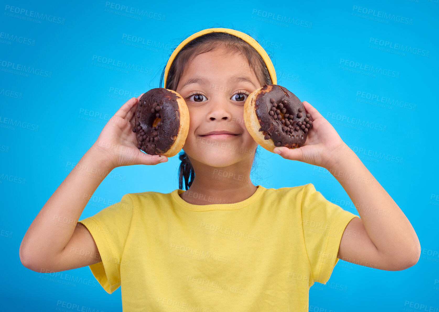Buy stock photo Donut, happy and smile with portrait of girl in studio for junk food, sugar and happiness. Snack, cake and cute with face of child and dessert for eating, diet and chocolate on blue background