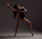 Ballet, woman and dancer with pose, exercise and training for performance on a dark studio background. Female performer, ballerina and artist with technique, practice routine for show and elegant art