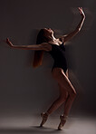Art, dance and woman in the dark for ballet isolated on a black background in a studio. Creative, elegant and contemporary dancer dancing for a theater performance, rehearsal or ballerina movement