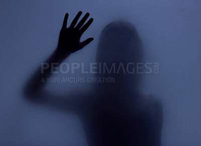 Buy stock photo Shadow, glass and hand with a woman in studio on a blue background for mystery or sensual secrecy. Creative, silhouette and window with a female posing for beauty, art deco or feminine desire