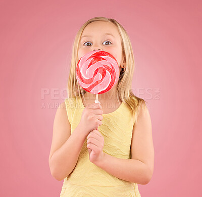 Buy stock photo Candy, sugar rush and lollipop with girl in studio for sweets, party and carnival food isolated on pink background. Cute, excited and youth with child and eating colorful snack for playful and treat