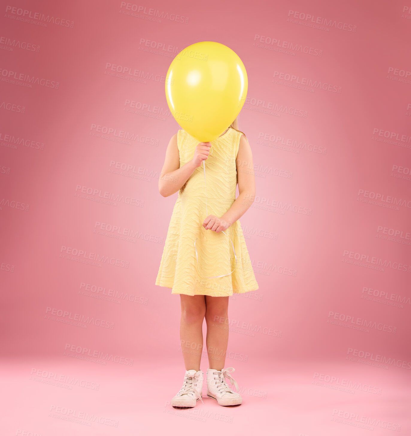 Buy stock photo Balloon cover face, girl and child in studio isolated on a pink background mockup. Children, birthday party and celebration event with young shy kid hiding with yellow air ballons and inflatable.