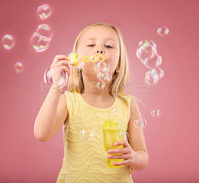 Buy stock photo Portrait, fun and girl blowing bubbles, content and playing in studio while posing against pink background. Hand, face and child enjoying freedom, toy and innocent magic while standing isolated