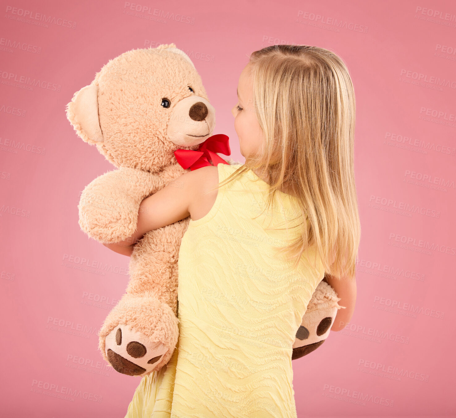 Buy stock photo Teddy bear, happy and back of a child in studio with a big, fluffy and cute toy as gift or present. Adorable, innocent and young girl kid hugging her teddy with care and happiness by pink background.