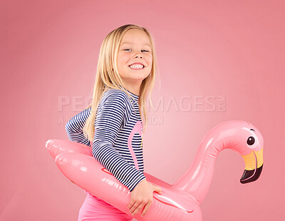 Buy stock photo Happy, portrait and pool float with girl in studio for swimming, summer break or cute. Youth, funny and inflatable with child and flamingo ring for relax, smile or beach holiday on pink background