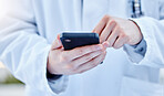 Closeup, hands and doctor with smartphone, online reading or connection for typing. Zoom, medical professional or cellphone for social media, research or search internet for information or healthcare