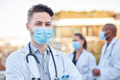 Face mask, covid doctor and man portrait outdoor with arms crossed for medical and health insurance. A happy healthcare worker with ppe for corona virus safety and compliance for wellness and help