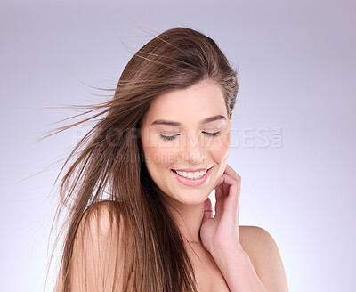 Buy stock photo Beauty, hair and wind with a model woman in studio on a gray background for haircare or keratin treatment. Shampoo, salon and natural with an attractive young female posing in a breeze on a wall