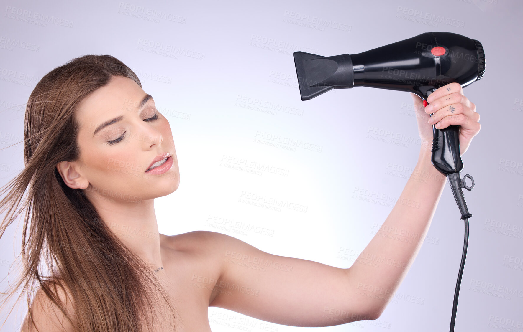 Buy stock photo Beauty, hair dryer and a woman blowing her hairstyle in studio on a gray background for grooming or style. Salon, cosmetics and appliance with an attractive young female using heat to blowdry