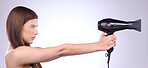 Hair care, dryer and woman with a styling product isolated on a white background in studio. Salon, beauty and a model with a cosmetic tool from a hairdresser for a hairstyle as a weapon on a backdrop