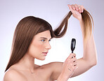 Magnifier, haircare and woman with magnifying glass checking hair damage isolated in a studio white background. Beauty, treatment and sad female model doing hairstyle health inspection of growth