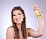 Beauty face, hair care and woman with spray in studio isolated on a gray background. Cosmetics, portrait smile and happy female model with hairspray product for salon treatment, growth and hairstyle.