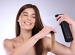 Hair care, beauty smile and woman with spray in studio isolated on a gray background. Cosmetics, keratin and happy young female model with hairspray product for salon treatment, growth and hairstyle.