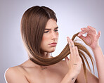 Face, beauty and hair loss of sad woman in studio isolated on a gray background. Angry, haircare and upset female model with keratin hairstyle problem, split ends and damage after salon treatment.