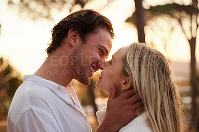 Buy stock photo Love, happy and kiss with couple in nature for romance, bonding and affectionate together. Close, happiness and embrace with man and woman hugging on date for sunset, anniversary and summer break