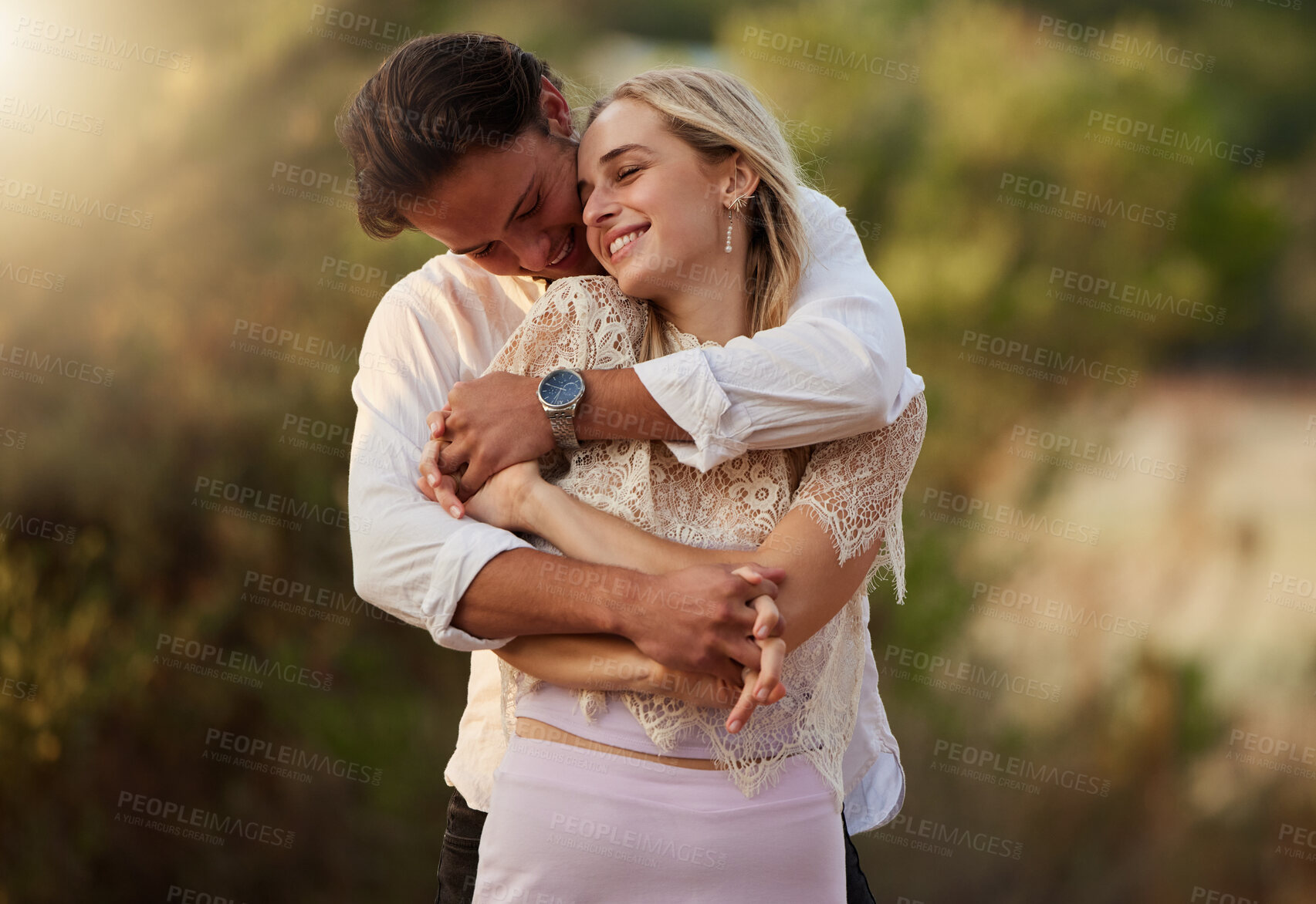 Buy stock photo Couple, love and hug outdoor for care, trust and romance with safety and security. Happy man and woman together on valentines day date with flare, peace and freedom in nature forest holding hands