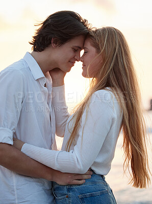 Buy stock photo Love, kiss and sunset with couple at beach for romance, relax and vacation trip. Travel, sweet and cute relationship with man and woman hugging on date for summer break, affectionate and bonding