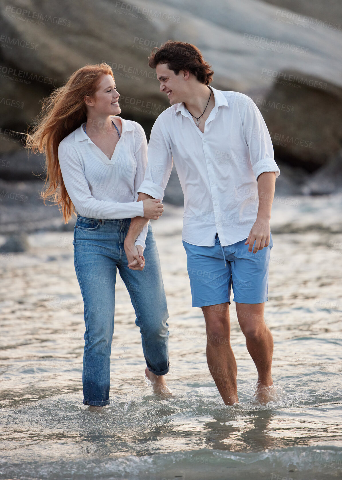 Buy stock photo Couple walking in ocean, holding hands and travel with love and commitment in relationship with adventure at beach. Trust, partnership and care with people outdoor, romance and happiness together