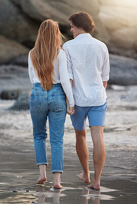 Buy stock photo Couple walking on beach, holding hands and travel with love and commitment in relationship, adventure and romance. Trust, partnership and care with people outdoor, tropical holiday and back view