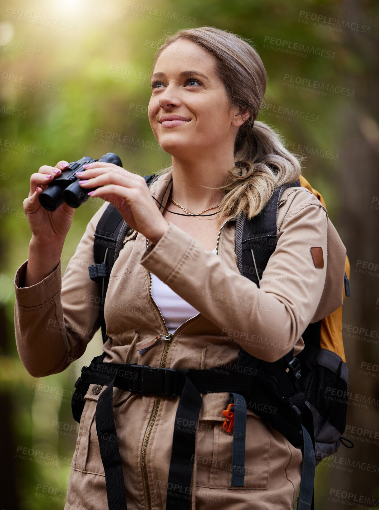 Buy stock photo Binocular, forest and hiking happy woman in travel journey, jungle adventure or nature explore with backpack gear. Fitness hiker or camper person trekking in woods and search or birdwatching outdoor
