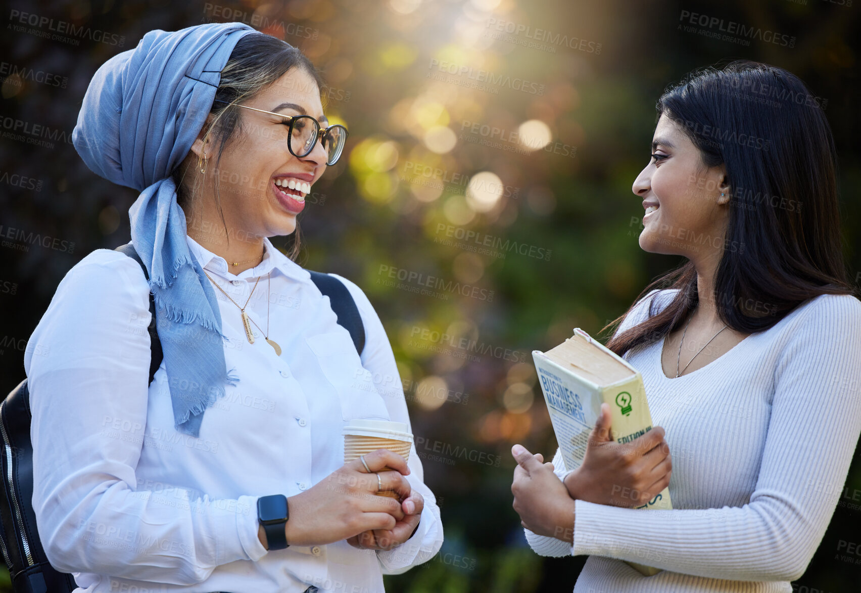 Buy stock photo Happy, break or students laughing in park on university campus for learning, education or books together. Girls talk, Islamic or funny friends relaxing or meeting for research or college knowledge 