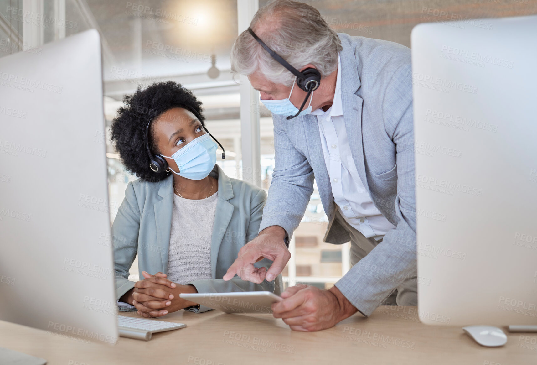 Buy stock photo Covid, black woman and man with tablet at call center with mask coaching and helping at help desk. Compliance, consulting and opinion, crm data for medical advisory agency with diversity and support.