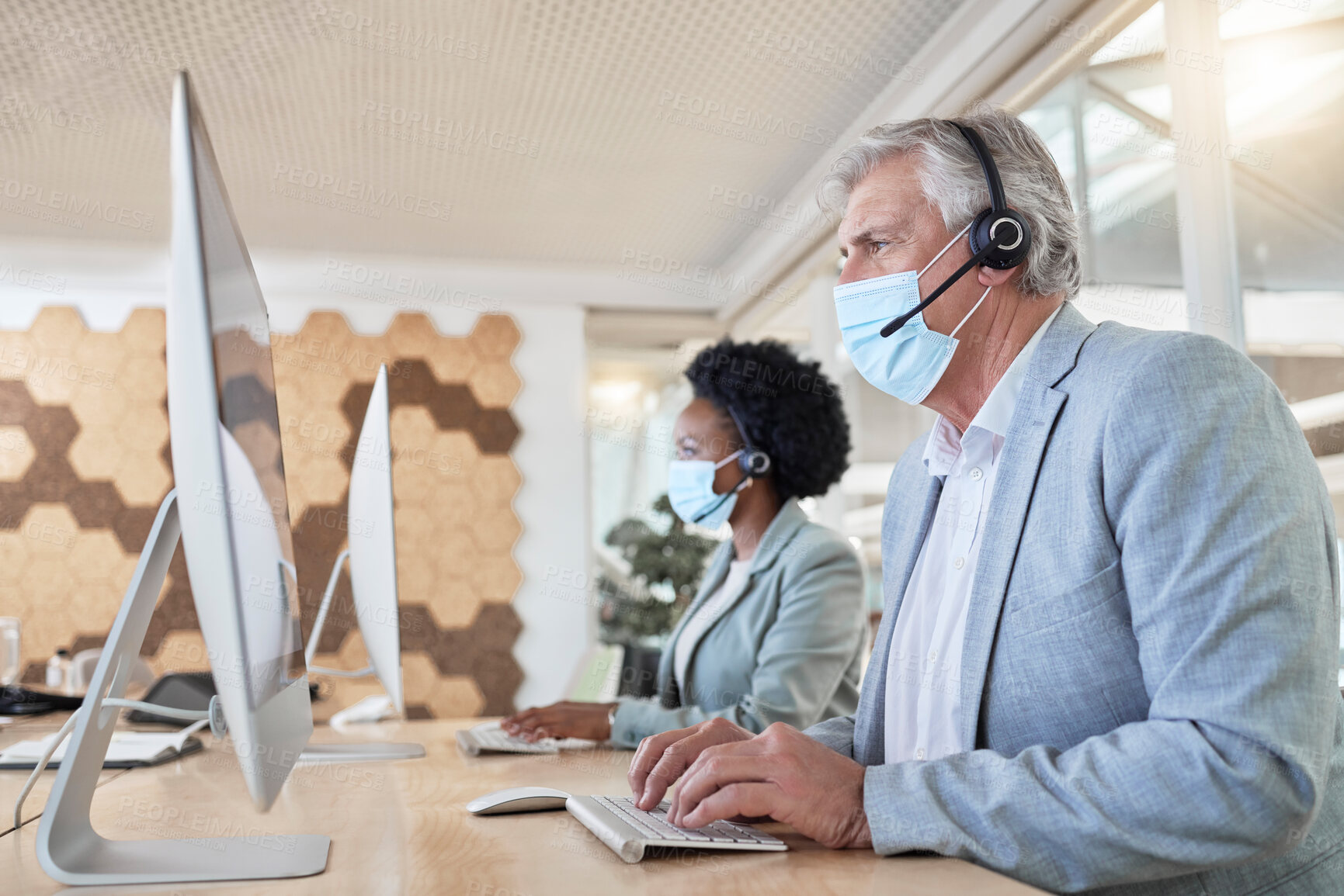 Buy stock photo Covid, call center employees with mask at computer and senior man with black woman in headset. Office compliance, consulting team online in shared workspace and medical advisory agency with diversity