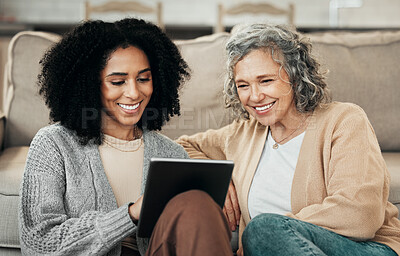 Buy stock photo Senior woman, tablet and tech teaching with a mixed race female in a living room showing a app. Family, happiness and home with people watching and streaming a video on technology with a smile