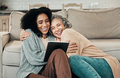 Buy stock photo Tablet, daughter hug and happy senior mother with digital photo album, bonding and enjoy quality time together at home. Living room floor, memory and biracial family, people or mom and girl embrace